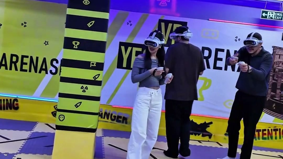 Arenada VR gözlüklü oyuncular, arkada YES VR duvar yazısı